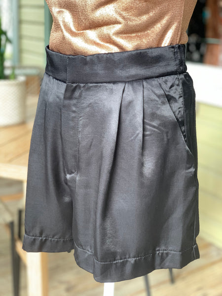 Black satin high waist shorts with side pockets and elastic waist at the back.